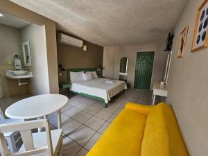 伊达尔戈州波萨里卡Hotel Punto Poza Rica的一间卧室配有一张床、一张桌子和一张桌子