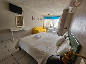 伊达尔戈州波萨里卡Hotel Punto Poza Rica的一间卧室设有一张床和一间客厅。