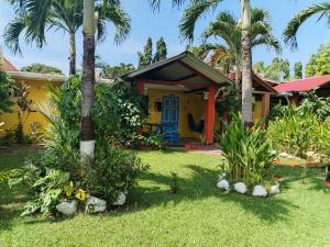 普拉亚科罗纳多Las Catalinas Coronado的棕榈树前方的黄色房子