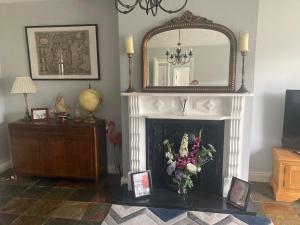 The Stay @ 155的客厅设有壁炉、镜子和鲜花