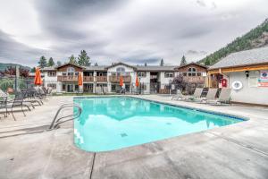 莱文沃思Icicle Village Resort 401 Aspen Abode的度假村的游泳池配有椅子和遮阳伞