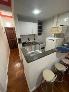 里约热内卢Apartamento na Zona Sul Carioca的一个带柜台和凳子的小厨房