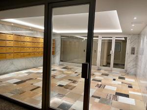埃维昂莱班Evian appartement confort Vue lac et parking privé的大堂设有玻璃门,铺有瓷砖地板。