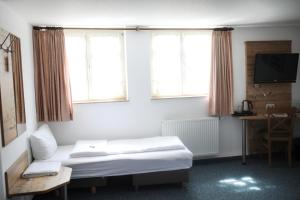 斯特滕阿卡顿玛Gasthaus Hotel zum Kreuz的酒店客房设有一张床和两个窗户。
