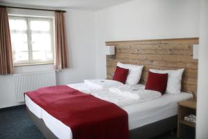 斯特滕阿卡顿玛Gasthaus Hotel zum Kreuz的一间卧室配有一张带红色枕头的大床