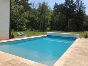 塔罗讷河畔绍蒙logement avec accès piscine的一个带两把椅子的庭院内的游泳池