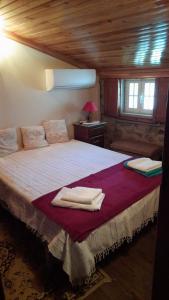 戈韦阿A Casinha do Beco的一间卧室配有一张大床和毛巾