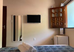 莫罗圣保罗Pousada Estevao的卧室设有壁挂式电视和床。