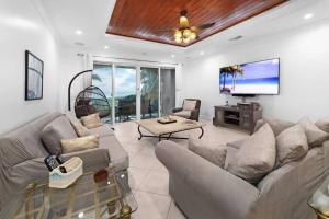 自由港市Paradise Retreat, A Tropical Oceanfront Villa的带沙发和平面电视的客厅