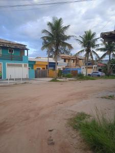 TamoiosCasa de Praia / Cabo Frio的一条有房屋和棕榈树的街道,一条土路