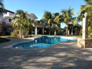 El CardónVilla Cocuyo Studios的棕榈树屋前的游泳池