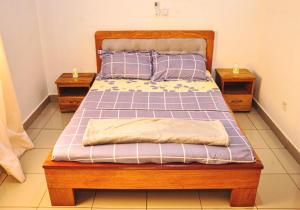 雅温得LES LOGIS DE NOUVELLE ROUTE BASTOS的卧室内的一张床位,带2个床头柜
