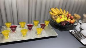 贝洛奥里藏特维勒塞莱斯蒂纳活动公寓式酒店的酒杯盘和一碗水果