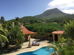 El CardónVilla Cocuyo Studios的一座带游泳池和山脉的度假村