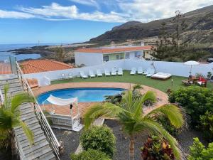 马佐Finca de Sal的一座带游泳池和椅子的度假屋,享有海景