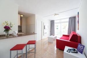 英格兰海滩EO拉斯罗萨斯公寓 的一间带红色沙发的客厅和一间厨房