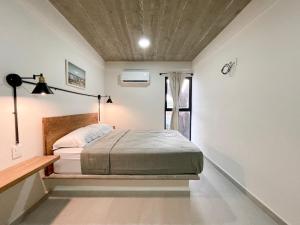 圣克鲁斯华特库Rooms Huatulco的一间卧室设有一张床和一个窗口