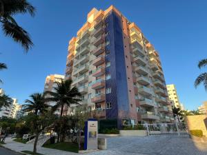 圣劳伦斯海滨FLAT RIVIERA COM VISTA MAR A 150m DA PRAIA !的一座高大的建筑,前面有棕榈树