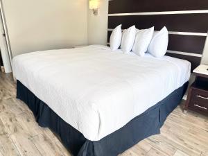 阿林顿Americas Best Value Inn Arlington的一张大床,位于酒店客房内,配有白色床单和枕头