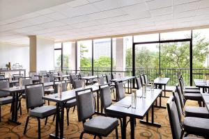 圣安东尼奥圣安东尼奥万豪河滨酒店的用餐室设有桌椅和窗户。