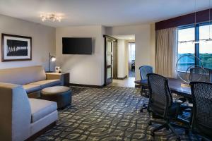 达拉斯达拉斯爱田希尔顿合博套房酒店的酒店客房设有沙发、桌子和书桌