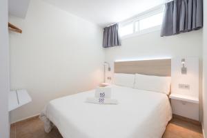 英格兰海滩EO拉斯罗萨斯公寓 的卧室配有白色的床和窗户。