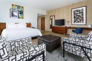 洛杉矶圣莫尼卡汉普顿酒店及套房的酒店客房配有床、椅子和电视。