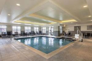 BerlinHomewood Suites by Hilton Boston Marlborough的酒店大堂的游泳池,配有桌椅