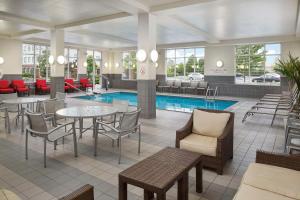 贝德福德公园DoubleTree by Hilton Chicago Midway Airport, IL的酒店大堂设有游泳池和桌椅