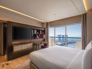 新加坡Swissotel The Stamford的酒店客房设有一张大床和一台电视。