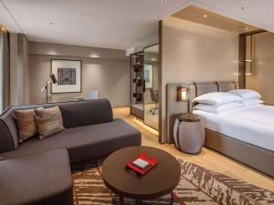 新加坡Swissotel The Stamford的酒店客房,配有床和沙发