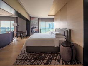 新加坡Swissotel The Stamford的一间卧室设有一张大床和一个大窗户