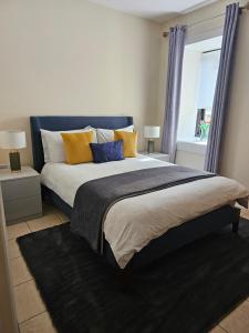 利特里姆The Koze的一间卧室配有一张大床,提供黄色和蓝色的枕头