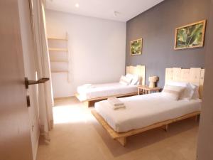 西迪拉哈尔Sidi Rahal Blue View, Piscine & mer sans vis-à-vis的一间客房内配有两张床的房间
