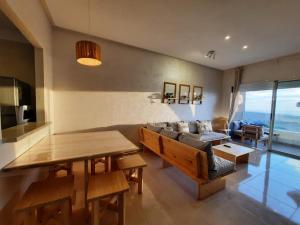 西迪拉哈尔Sidi Rahal Blue View, Piscine & mer sans vis-à-vis的客厅配有桌子和沙发