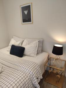 哥德堡Göteborgs Pärla的一张带黑白棉被的床和一张边桌