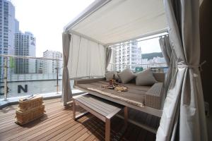 釜山Hound Hotel Minam的阳台配有沙发和大窗户。