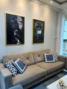 马卡帕Casa Almirante Premium的客厅配有棕色沙发和两张图片