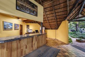 Chisamba普罗蒂亚野生酒店的度假村的户外酒吧拥有黄色的墙壁和木制天花板