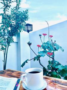 马尼拉Crosswinds Hotel的坐在桌子上,一边喝咖啡一边种植物