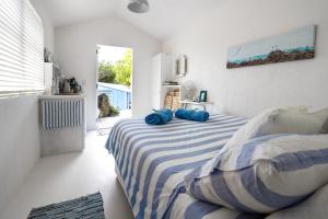 OstendBoatsheds on the Bay, Waiheke Island的一间卧室配有一张带蓝色枕头的床。