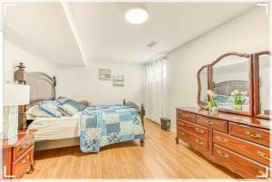 加蒂诺Leila`s place-Basement apartment in private home的一间卧室配有一张床、梳妆台和镜子