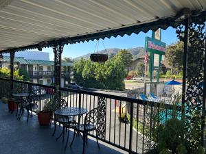 洛杉矶迎宾住宿加早餐旅馆的一个带桌椅的庭院和一个美景阳台。