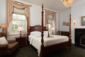 卡莱尔Carlisle House Bed and Breakfast的一间卧室配有一张床、一把椅子和一个壁炉
