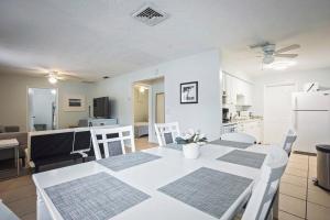 克利尔沃特Sunny Shores Retreat 1的厨房以及带白色桌椅的起居室。
