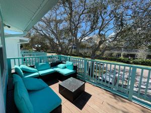 克利尔沃特Beachside Getaway West的阳台的门廊配有蓝色的椅子和桌子