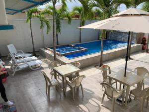 普拉亚斯Casa Halley #4 con vista al mar y piscina , 2 pisos - Villamil Playas , Data de Villamil的游泳池旁配有遮阳伞的桌椅