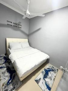 哥打丁宜Baiduri Homestay的白色的客房配有床和吊扇。
