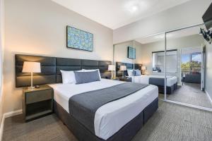 达尔文Hudson Berrimah的酒店客房设有一张大床和一间卧室。