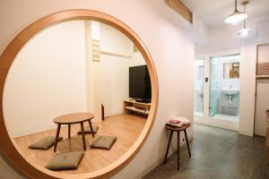 台南錦小路包棟民宿 Nishikikoji inn的客厅里设有一张大圆镜,配有桌子和凳子